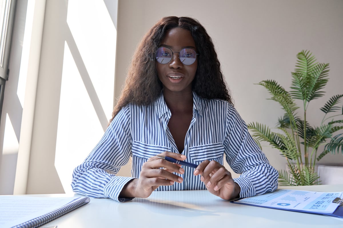 Woman in Corporate Clothing Holding a Pen 